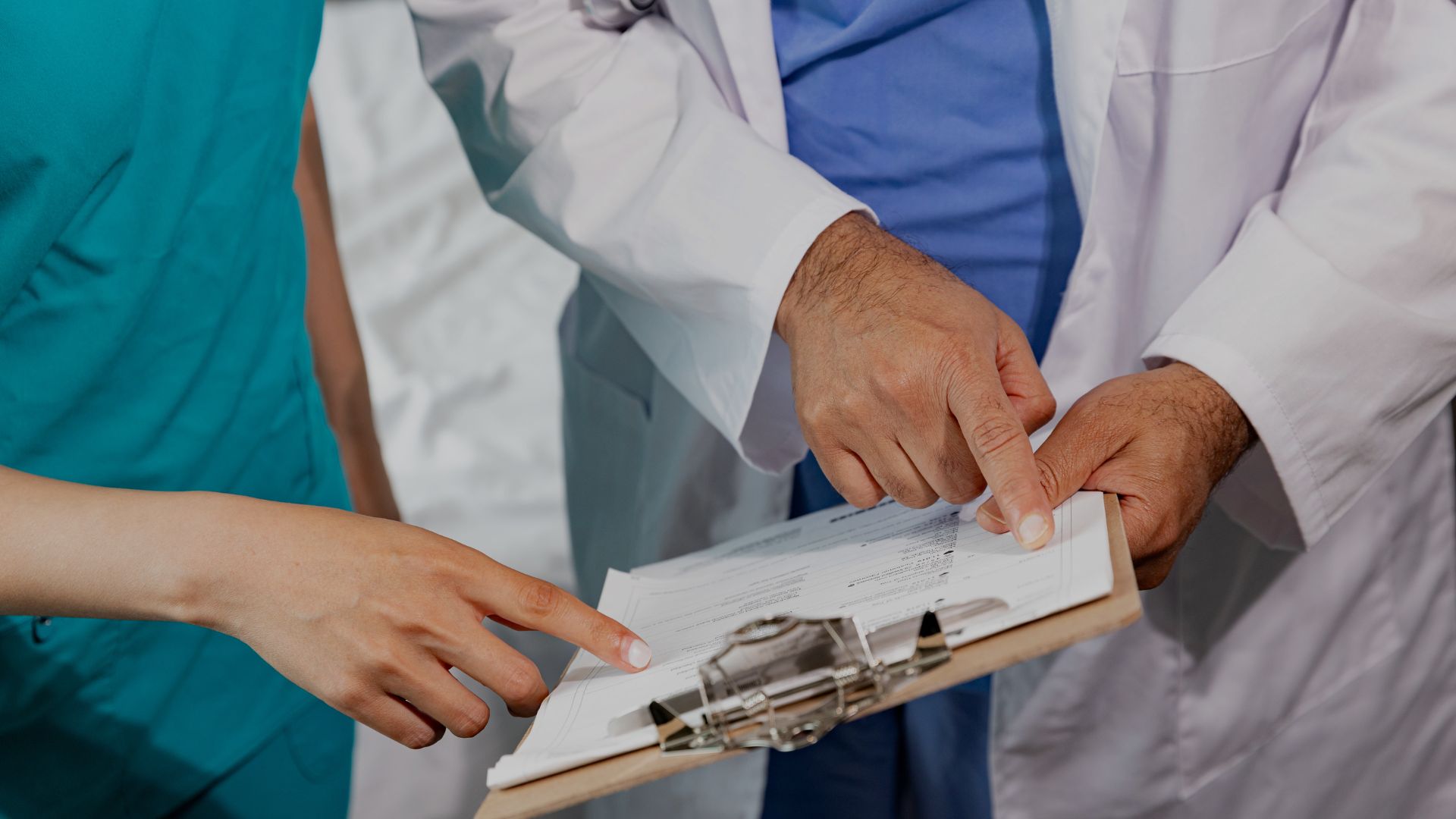 a doctor pointing at a clipboard