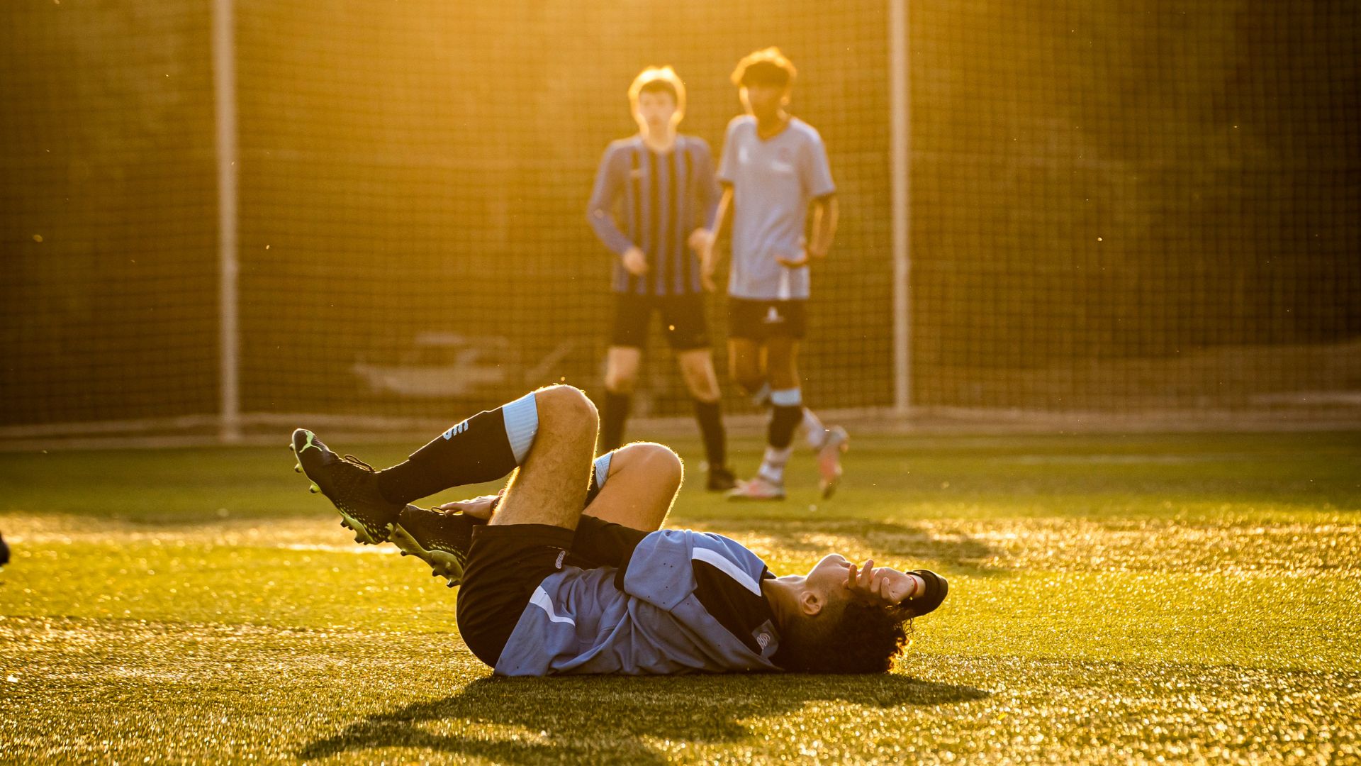 a man lying on the ground with other men in the background