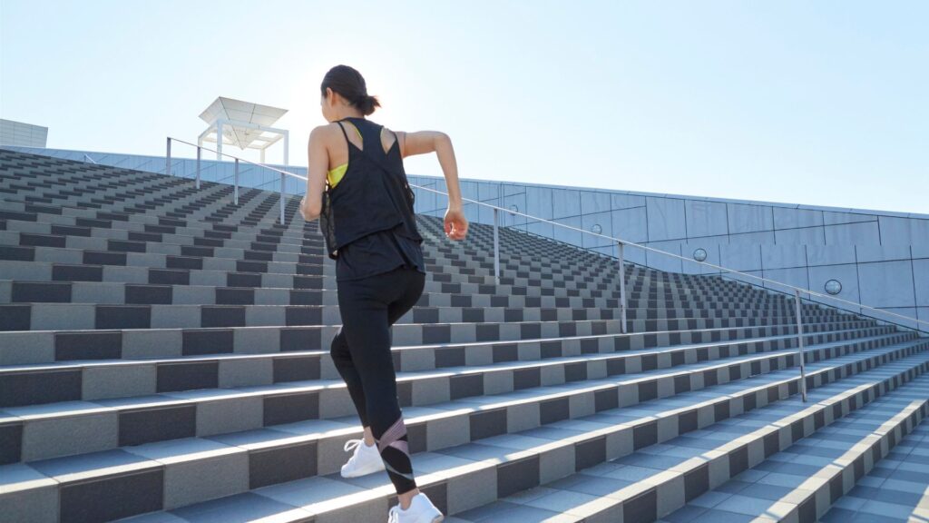 Woman running up bleacher steps