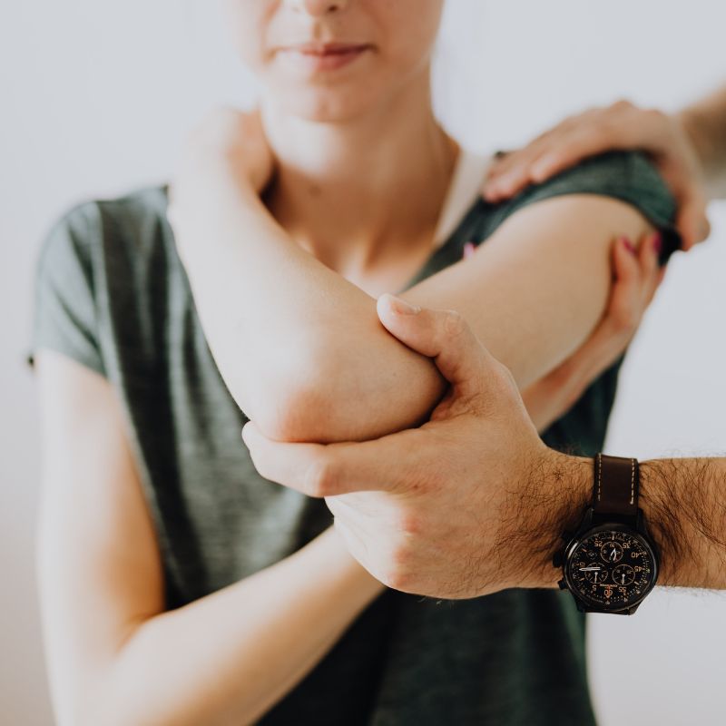 a patient being examined by an orthopedic specialist on her shoulder pain