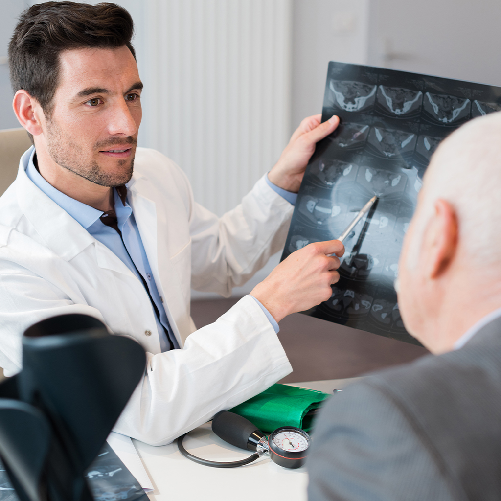 An orthopedic doctor consulting with a patient in an Austin clinic about post-traumatic hip arthritis treatment options.